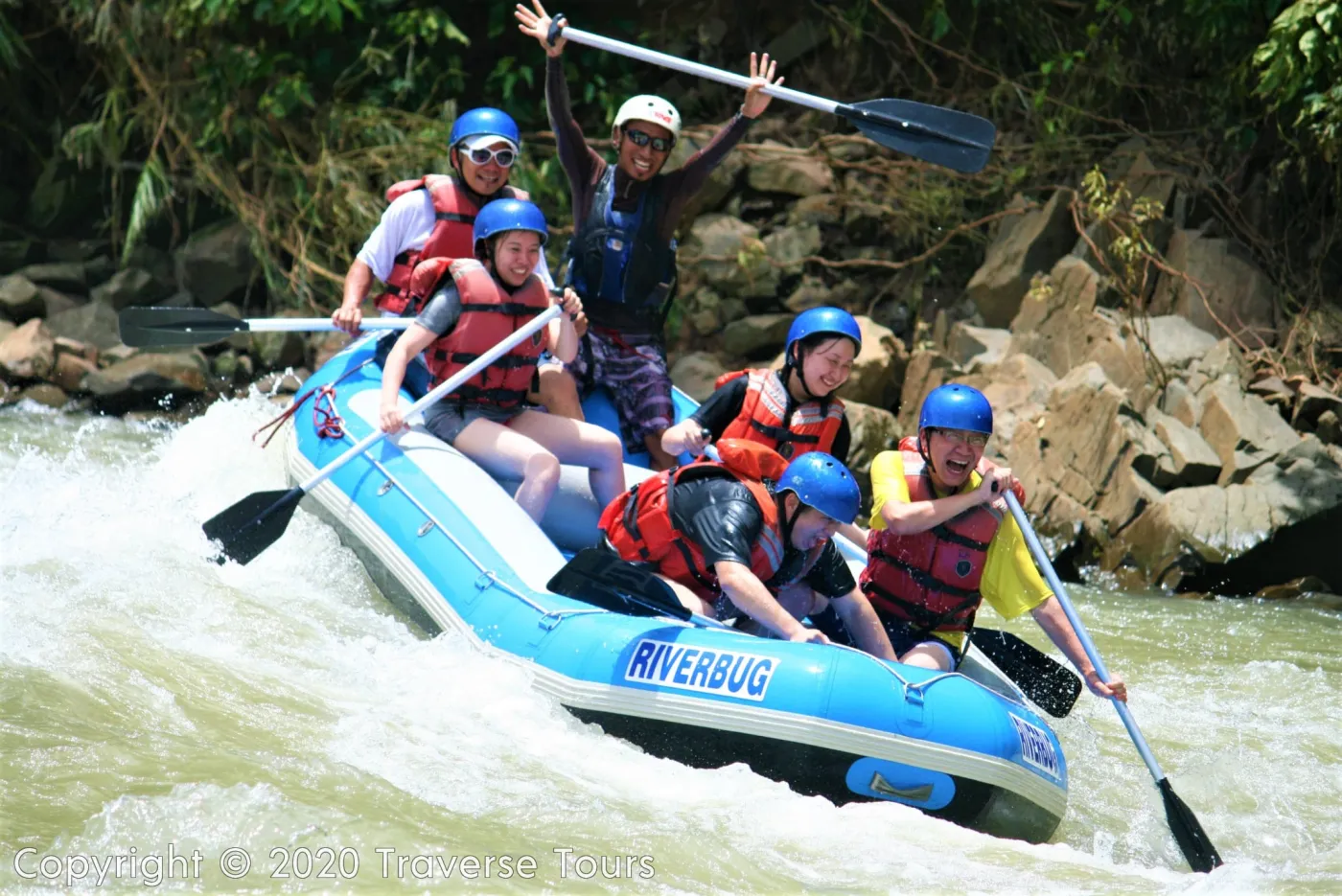 A Riverbug raft crew splashing through the Kiulu River rapids